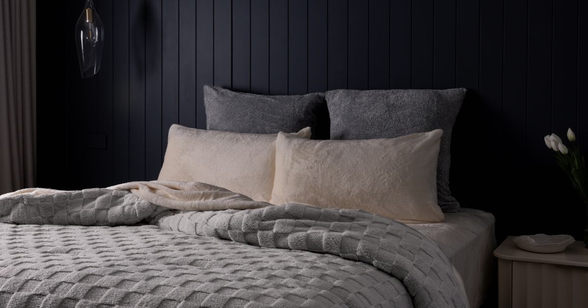 Silver checked comforter on a bed in a dark moody room