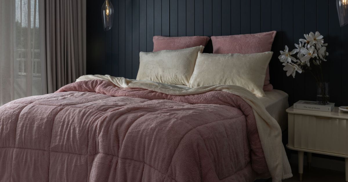 A pink fluffy comforter on a king bed