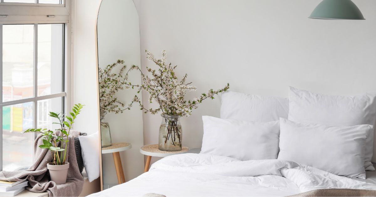 White bedroom with window with white sheets on bed